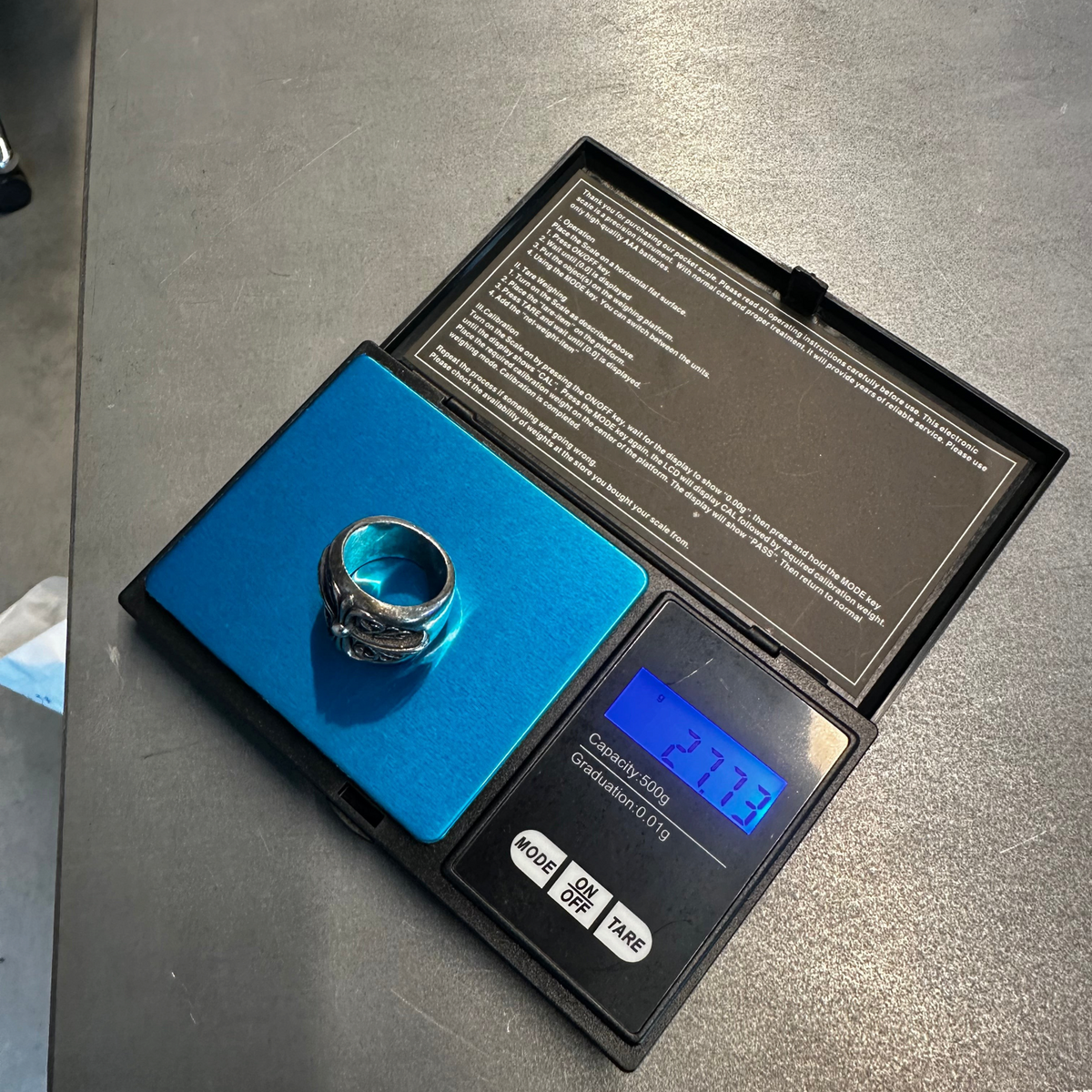 Zenno Archive Chrome Hearts Oval Cross ring in sterling silver resting on a digital scale showing 27.73 grams