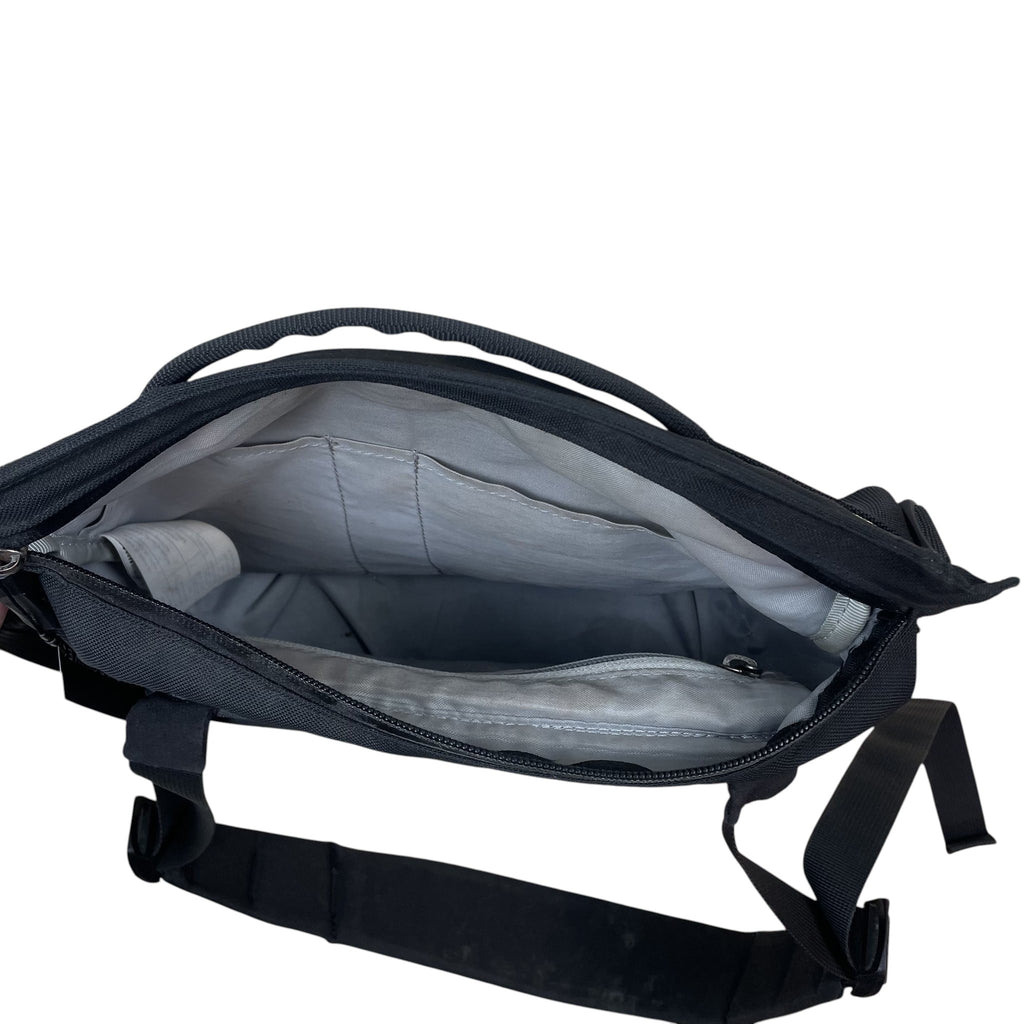 Zenno Archive Arc’teryx Arro 8 shoulder bag in black, showing the open interior compartment with light grey lining.