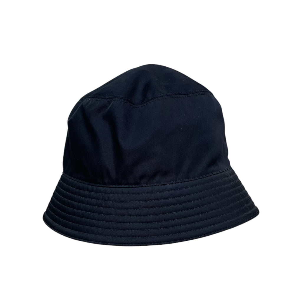 Zenno Archive black nylon bucket hat with iconic triangle logo plaque on a metal display stand