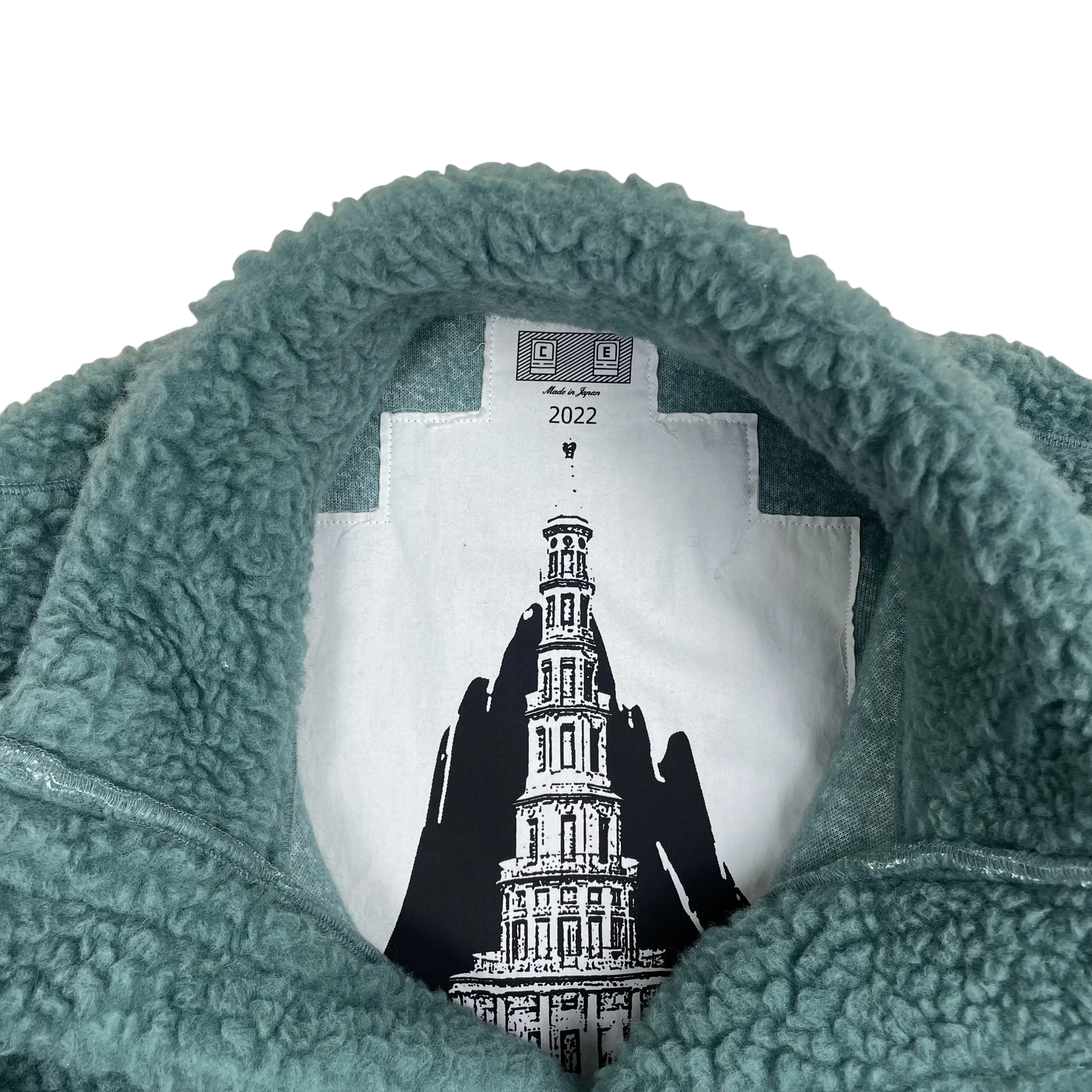 Zenno Archive Cav Empt turquoise fleece pullover with asymmetric zip and internal graphic tower print label