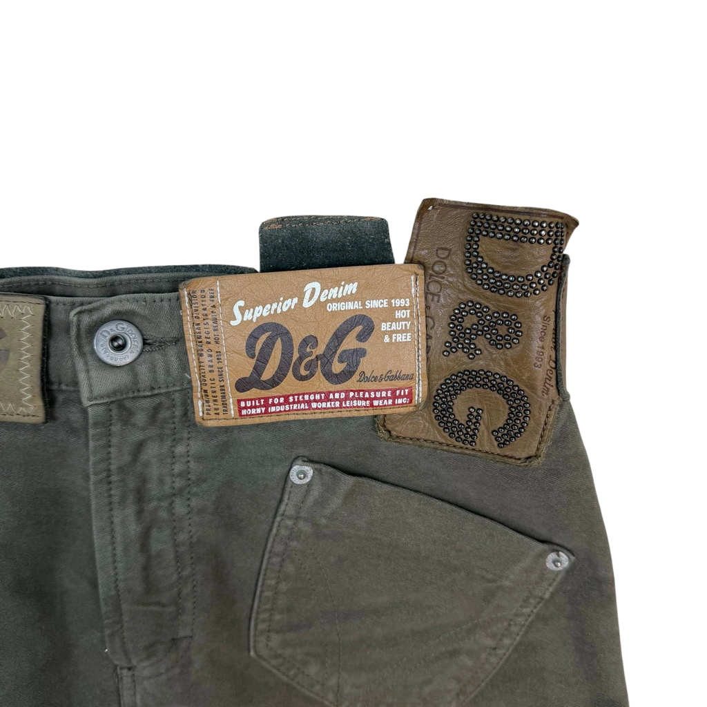 Zenno Archive Dolce & Gabbana AW03 khaki green skirt featuring multiple branded leather and denim tags with studs.