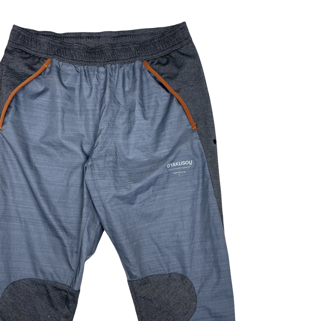 Zenno Archive Nike x Undercover Gyakusou grey technical running pants with orange trim and reinforced knee patches.