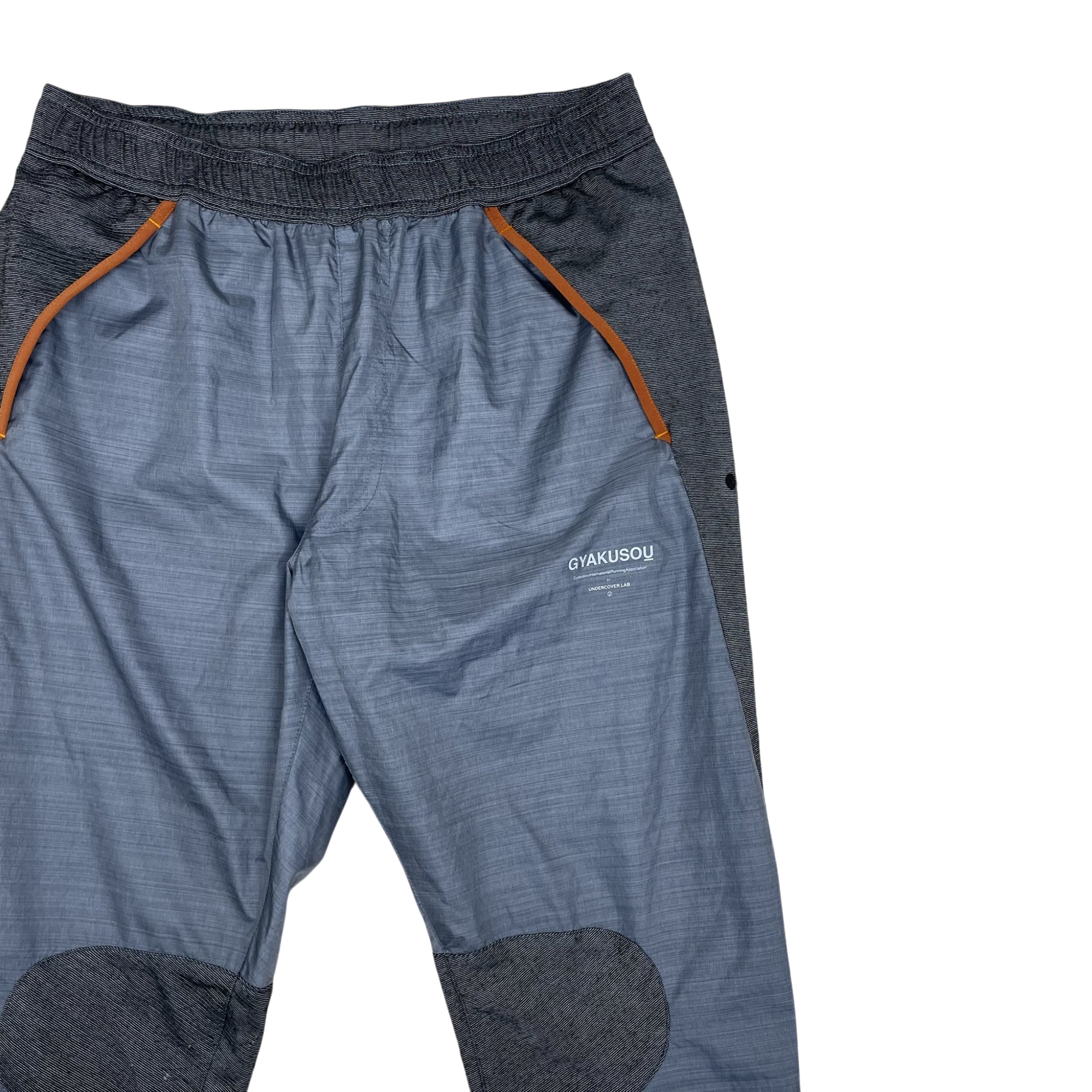 Zenno Archive Nike x Undercover Gyakusou grey technical running pants with orange trim and reinforced knee patches.