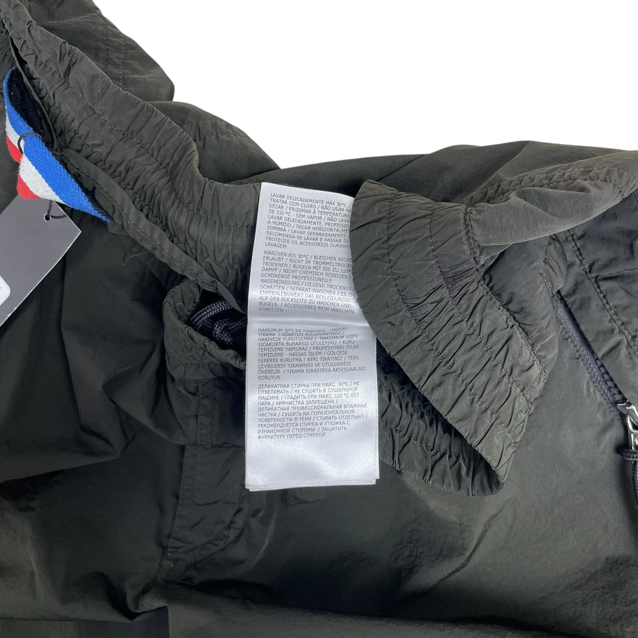 Zenno Archive Moncler 1952 dark green nylon pants featuring an interior care label and signature tricolor trim