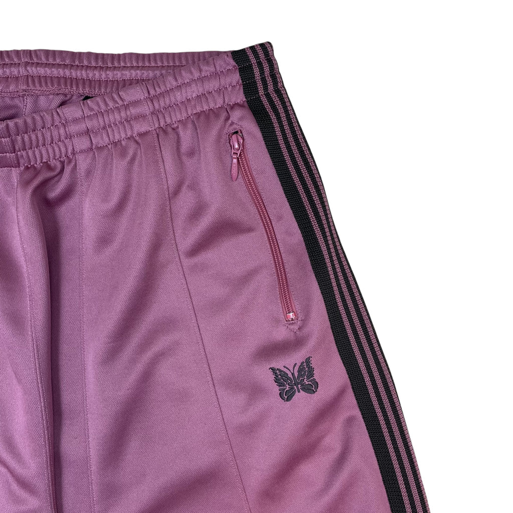 Zenno Archive Needles H.D. track pants in pink with black side stripes, zipper pocket, and embroidered butterfly logo.