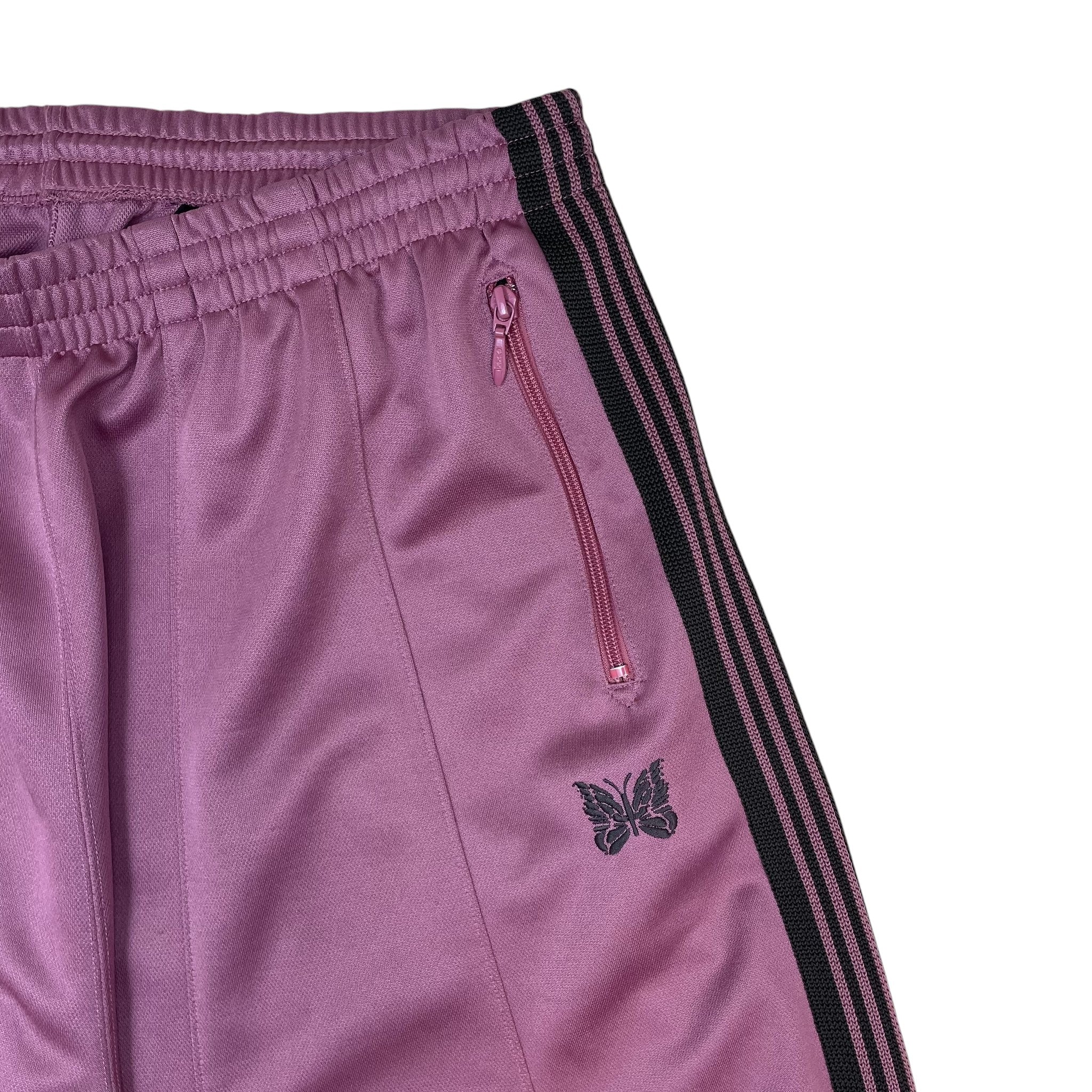 Zenno Archive Needles H.D. track pants in pink with black side stripes, zipper pocket, and embroidered butterfly logo.