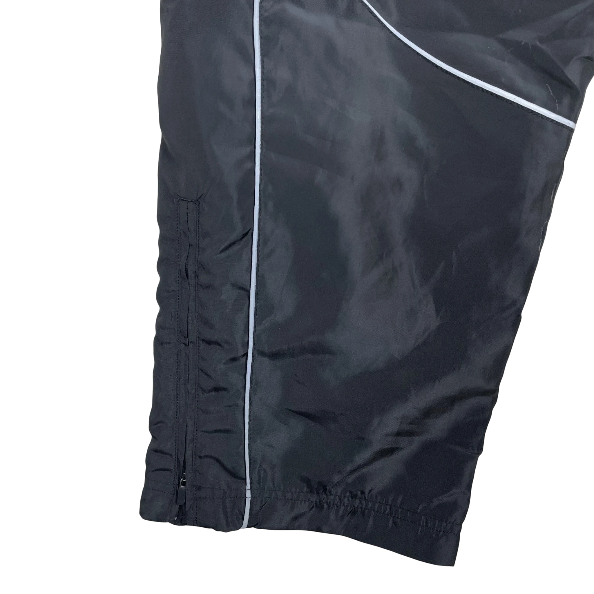 Zenno Archive Nike x Corteiz black track pants featuring reflective 3M piping and a zippered leg hem detail.