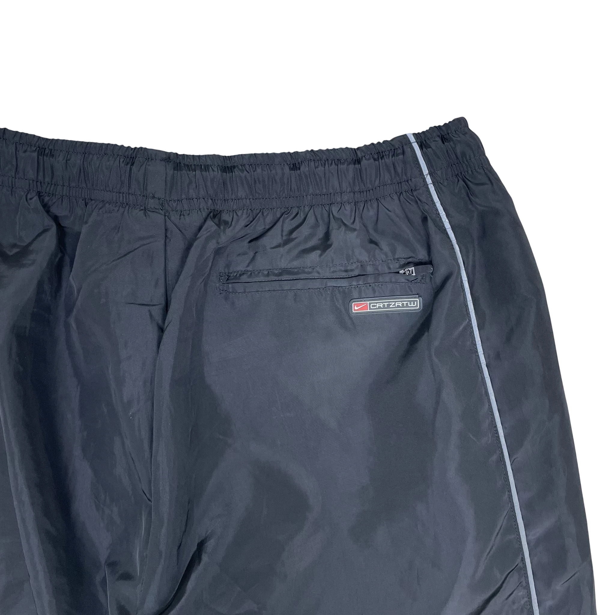 Zenno Archive Nike x Corteiz black track pants featuring 3M reflective piping and a zippered back pocket