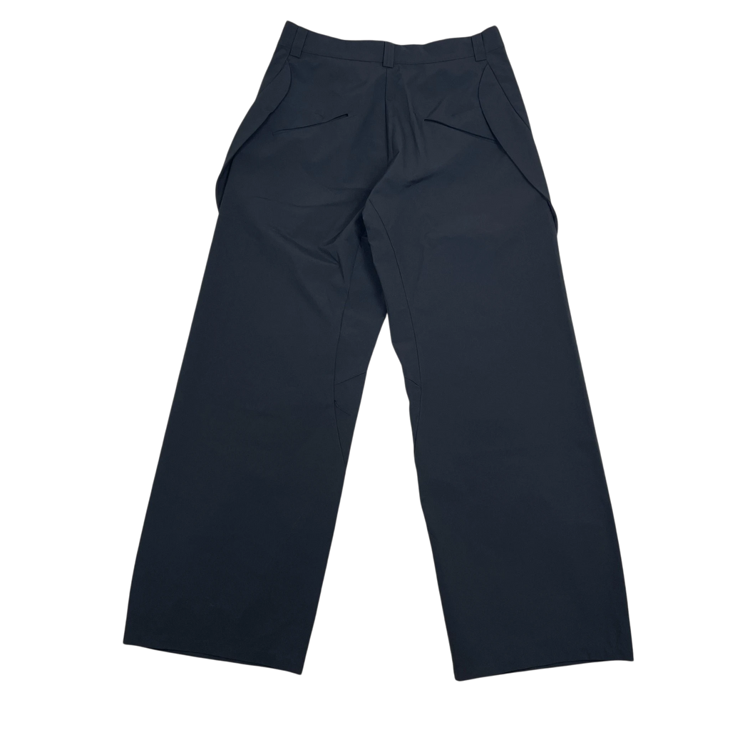 Zenno Archive Nouveou Project black technical trousers with unique pocket flap detailing on a textured background.