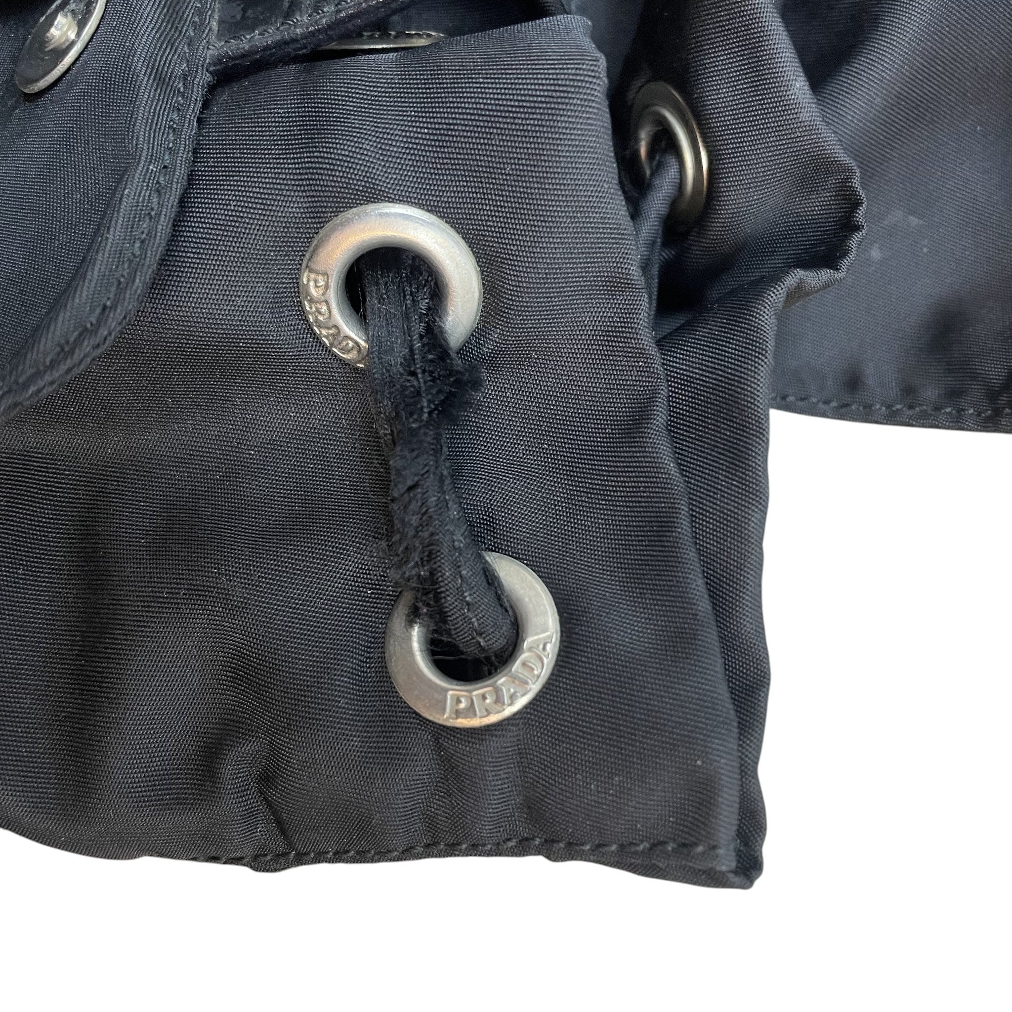 Zenno Archive Prada Tessuto Montagna black nylon backpack detail featuring silver-tone branded metal eyelets and cord