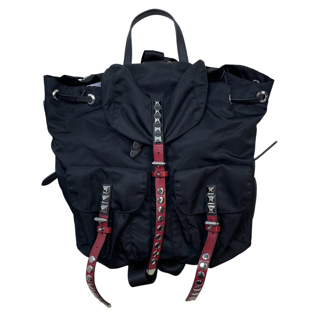 Zenno Archive Prada black nylon backpack featuring silver pyramid studs and red leather buckle straps.