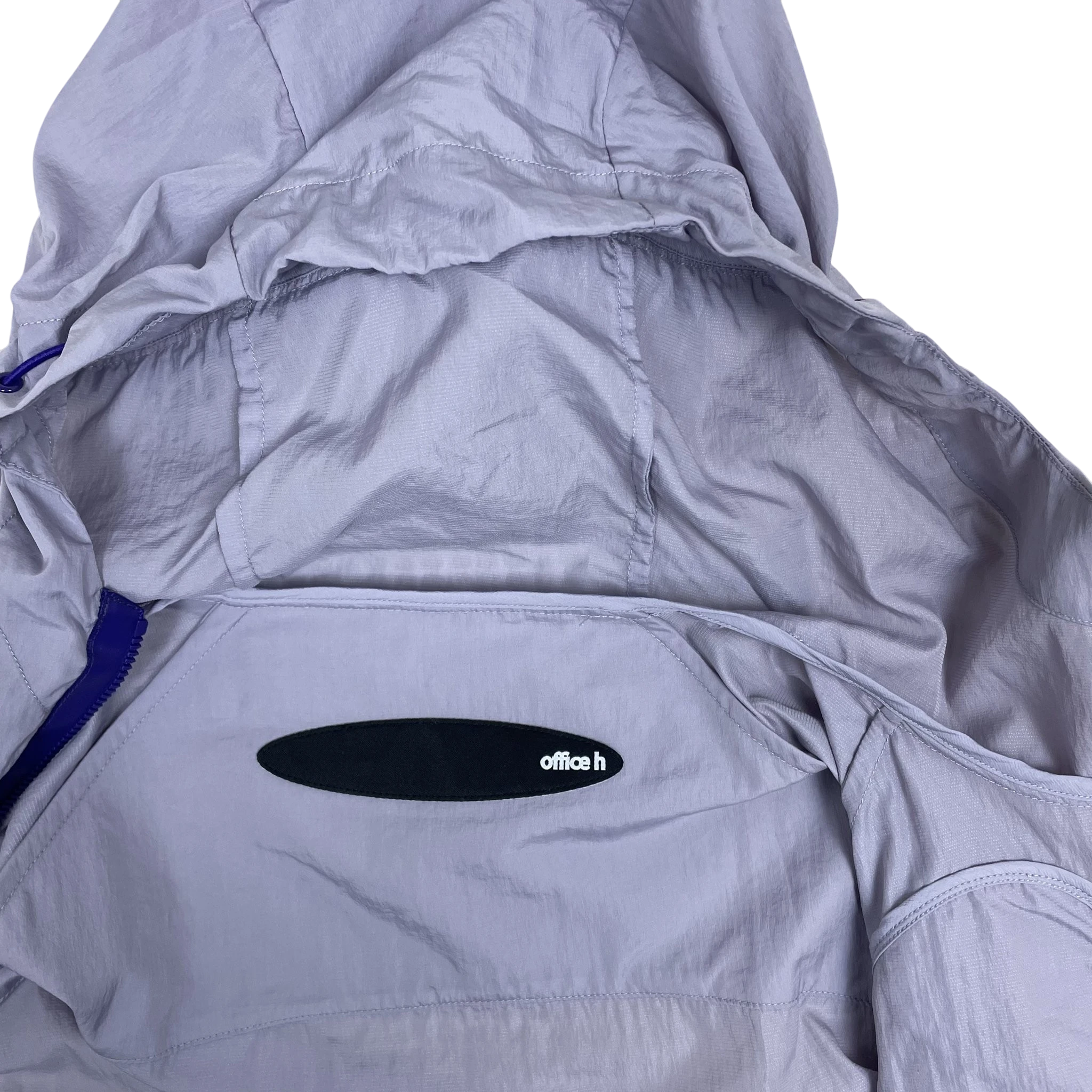 Zenno Archive Office H purple nylon hooded jacket with a black logo patch and contrasting blue zipper detail